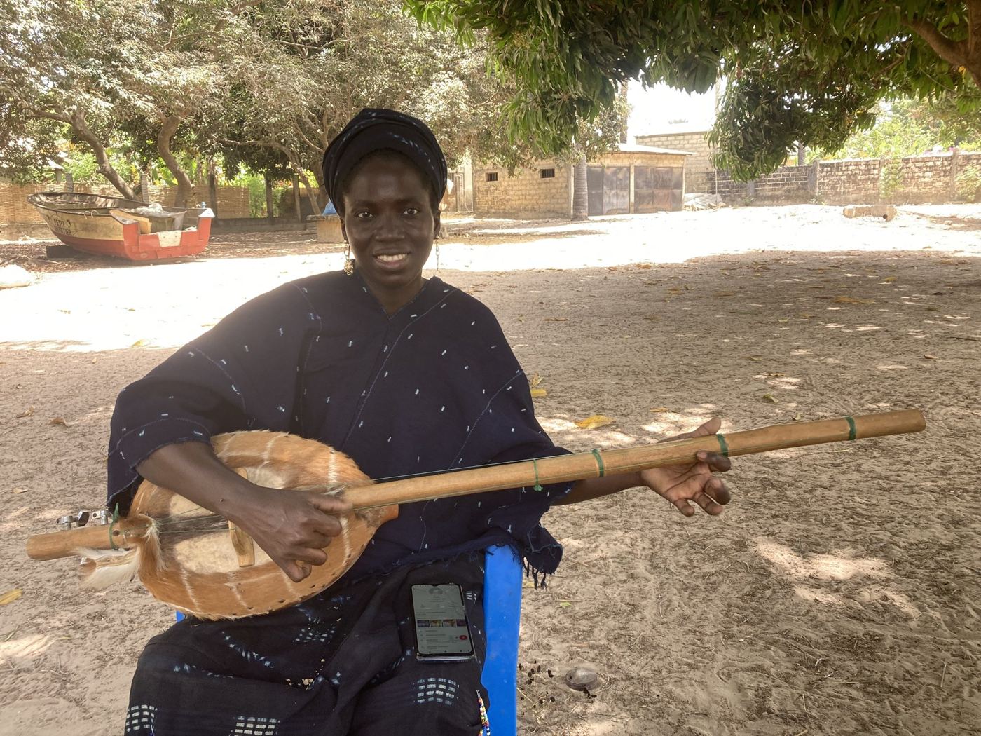 A woman playing a stringed instrument in the shade