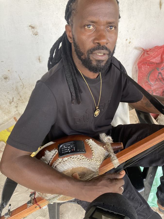 A man with long locks playing a stringed instrument