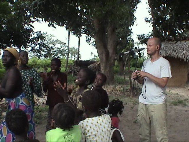 Tobias recording a group of villagers with a microphone
