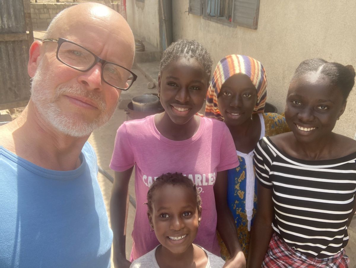 A smiling group of young people and a visitor in Casamance